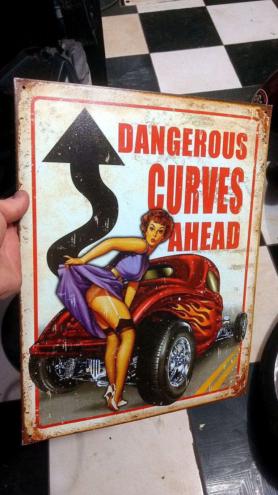 Placa decorativa vintage "Dangerous Curves Ahead" na oficina